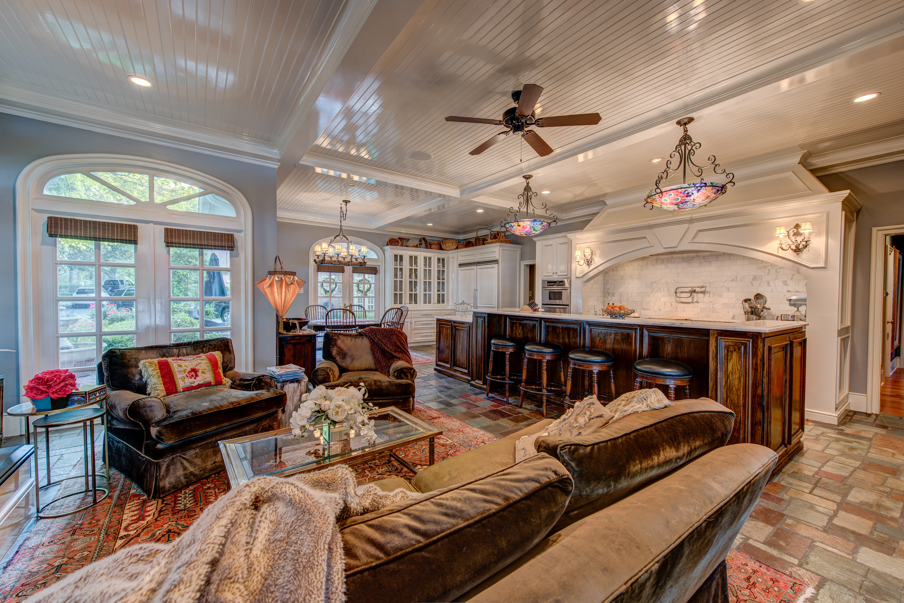 a traditionally styled kitchen with a large island and a cozy den